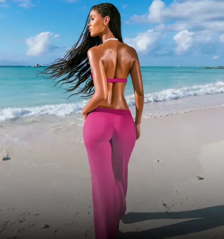 Model poses in a raspberry sports bra and matching active pants. 