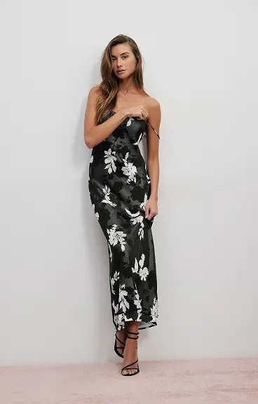 Model is wearing a black floral slip dress.