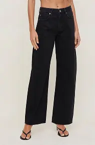 Model is wearing barrel leg jeans.