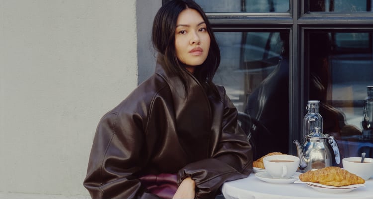 Model is wearing a brown faux leather cocoon jacket.