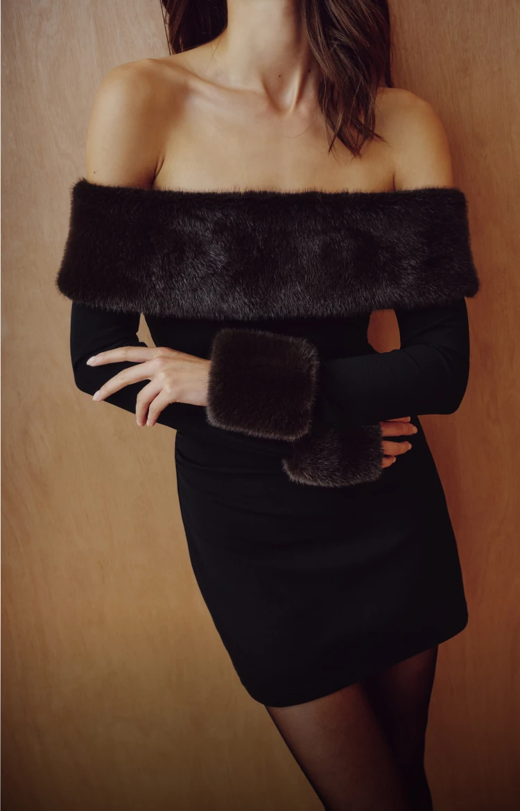 Model is wearing a black faux fur trim mini dress.