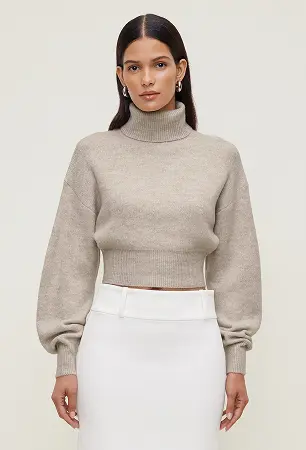 Model is wearing a beige turtleneck sweater and a white midi skirt.