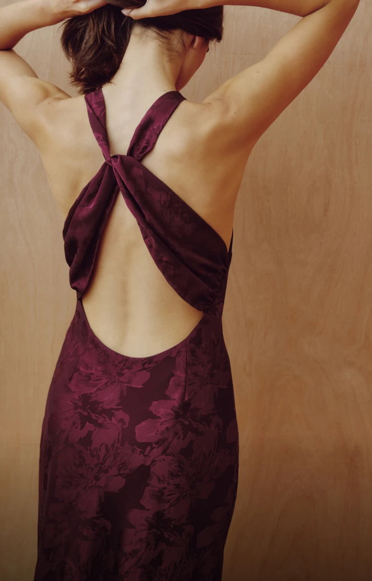 Model is wearing a floral burgundy maxi dress.
