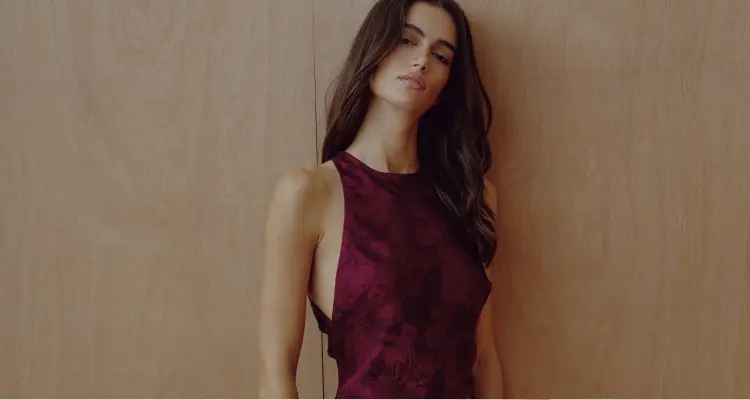 La mannequin porte une robe maxi bourgogne à fleurs.