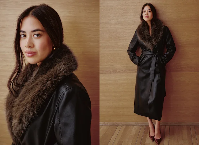 La mannequin porte un manteau noir orné d'une bordure en fausse fourrure.