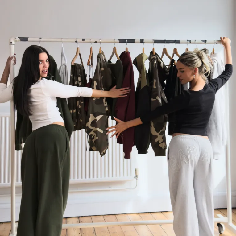 Deux mannequins prennent la pose dans des ensembles en molleton aux couleurs assorties.